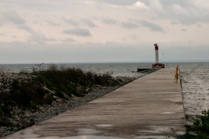 The lighthouse stands at the end of the pier. 