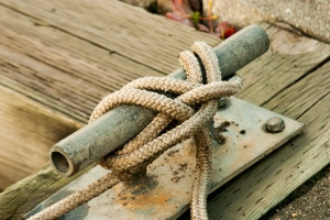 One rope is holding the ship from the sea… or lake.